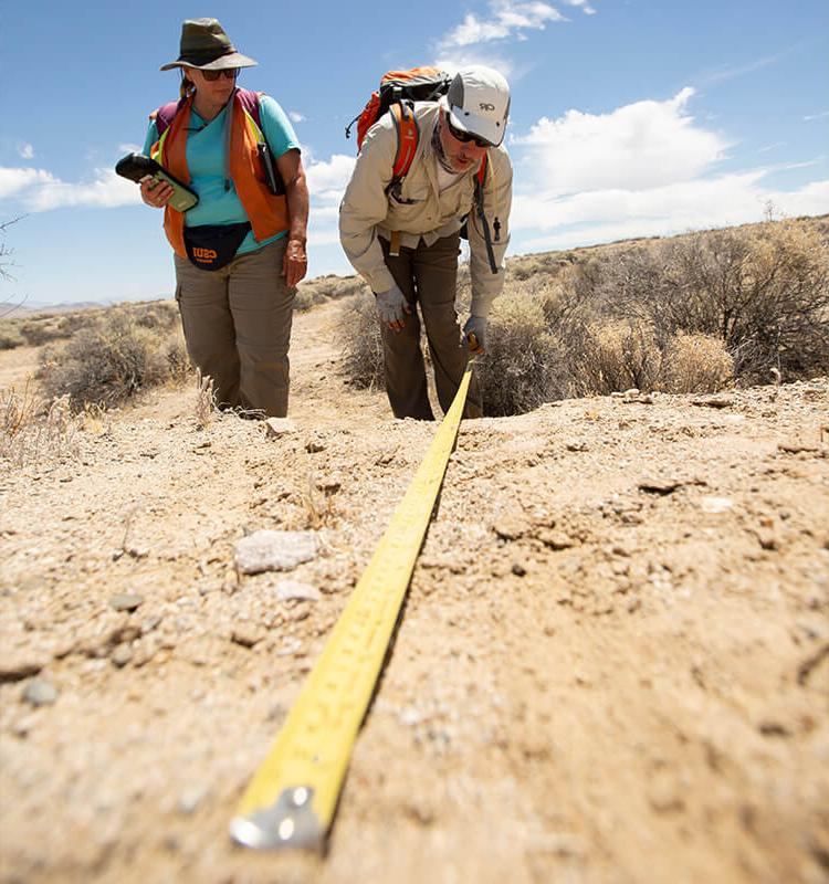 Researcher measures surface rupture with tape measure